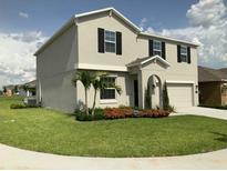 Charming two-story home featuring well-manicured lawn and tropical landscaping at 204 Taft Dr, Davenport, FL 33837