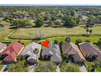 Beautiful aerial view of home on golf course featuring mature landscaping, solar panels, and pristine surroundings at 228 Sorrento Rd, Poinciana, FL 34759
