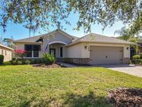 Charming single-story home featuring manicured landscaping and a two-car garage at 228 Sorrento Rd, Poinciana, FL 34759