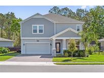 Beautiful two-story home with a manicured lawn, neutral paint, and a two-car garage at 3010 Camden Way, Davenport, FL 33837