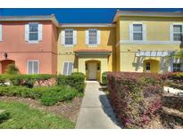 Charming townhome featuring vibrant colors, well-manicured landscaping, and a welcoming front entrance at 3101 Yellow Lantana Ln, Kissimmee, FL 34747