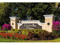 Venetian Bay Villages sign surrounded by colorful flowers and lush landscaping at 4002 San Gallo Dr # 106, Kissimmee, FL 34741