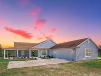 Charming single-story home with a covered front porch and well-manicured lawn at 41636 Outlaw Ln, Weirsdale, FL 32195