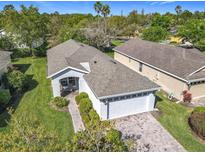 Aerial view of a well-maintained home with a brick driveway and lush green landscaping at 439 Madera Pass, Poinciana, FL 34759