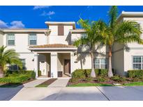 Charming two-story townhouse with a well-manicured lawn and mature palm trees at 4835 Lullaby Ln, Kissimmee, FL 34746