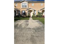 Inviting two-story townhome with a well-maintained lawn and driveway at 645 Captiva Cir, Kissimmee, FL 34741