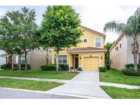 Charming two-story home features a yellow facade, attached garage, and well-maintained landscaping at 8945 Cuban Palm Rd, Kissimmee, FL 34747
