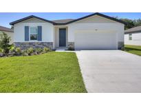 Charming single-story home with a well-maintained lawn and stone accents, complemented by a modern two-car garage at 1249 Oak Valley Dr, Auburndale, FL 33823