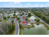 Aerial view of charming lakeside townhomes, featuring lush landscaping and serene water views at 2200 San Vittorino Cir # 105, Kissimmee, FL 34741