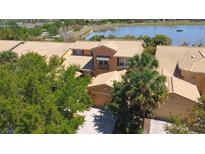 Beautiful townhouse near a lake with lush tropical landscaping and a clay tile roof at 2340 Palm Tree Dr, Kissimmee, FL 34759