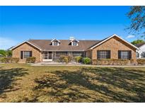 Charming brick home featuring dormer windows, mature landscaping, and manicured lawn at 3161 Appaloosa Ct, Kissimmee, FL 34746