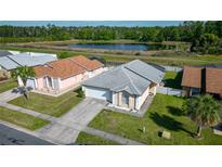 Charming single-story home boasts a well-manicured lawn and a serene lake view at 5275 Warrior Ln, Kissimmee, FL 34746