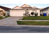 Charming single-story home with a well-manicured lawn, attached two-car garage, and freshly painted exterior at 529 Eagle Pointe N, Kissimmee, FL 34746