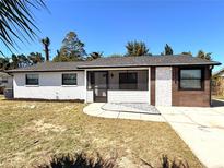Charming single-story home featuring a mix of brick and wood siding with a screened front porch and well-kept front lawn at 817 Clay Blvd, Eustis, FL 32726