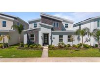 Modern two-story home with landscaped yard, stone accents, and contemporary design features at 9190 Sommerset Hills Dr, Davenport, FL 33896