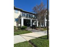 Charming townhome features a glass-railed balcony, covered porch, and beautifully landscaped front yard at 14129 Walcott Ave, Orlando, FL 32827