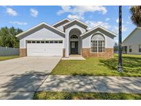 Charming one-story home with arched entryway, brick accents, well-kept lawn, and two car garage at 16245 Egret Hill St, Clermont, FL 34714