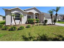 Charming single-story home featuring a well-maintained lawn, lush landscaping, and a decorative fountain at 213 Strathmore Cir, Kissimmee, FL 34744