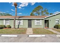 Charming exterior view of this condo featuring a well-kept lawn, white shutters, and neutral paint at 31 Las Palmas Way, Kissimmee, FL 34743