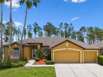 Charming mustard-colored single-Gathering home with a three-car garage and manicured lawn at 310 N Hampton Dr, Davenport, FL 33897
