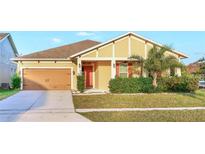 Charming single-story home with a manicured lawn and a attached two-car garage at 3131 Bass Boat Way, Kissimmee, FL 34746