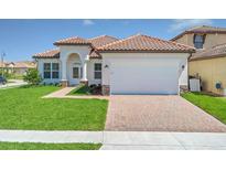 Charming single-story home featuring a red tile roof, arched entryway, and a brick-paved driveway at 362 Villa Sorrento Cir, Haines City, FL 33844