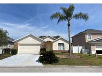 Charming single Gathering home with a two-car garage and a well-manicured lawn and a tall palm tree at 366 Jaybee Ave, Davenport, FL 33897