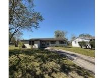 Charming single-story home with a classic design and a spacious front yard and a long driveway leading to the street at 4226 Lake Richmond Dr, Orlando, FL 32811