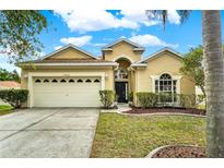 Charming one-story home featuring a manicured lawn, mature landscaping, and a two-car garage at 4900 Marbella Isle Dr, Orlando, FL 32837