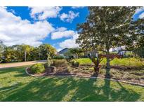 Beautifully landscaped front yard with lush lawn and mature trees leading up to a charming single-story home at 6051 Twin Lakes Dr, Oviedo, FL 32765