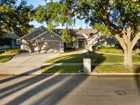 Beautiful single-story home with a well-maintained lawn, mature trees, and a two-car garage at 9424 Wickham Way, Orlando, FL 32836