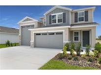 Stylish two-story home featuring a three car garage and beautifully landscaped front yard at 1138 Olivine Ave, Dundee, FL 33838