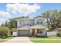 Charming two-story home featuring a brick driveway, attached garage, and well-manicured landscaping with green grass at 1436 Stetson St, Orlando, FL 32804