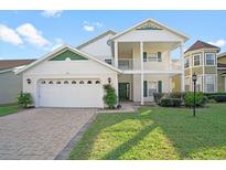 Charming two-story home with a well-manicured lawn and a two-car garage with brick-paved driveway at 2173 Victoria Dr, Davenport, FL 33837