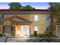Charming two-story townhouse with a terra cotta tile roof and light yellow exterior at 2621 Corvette Lane, Kissimmee, FL 34746