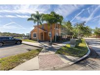 Charming two-story home with a terra cotta roof, palm trees, and convenient parking at 561 Las Fuentes Dr, Kissimmee, FL 34747