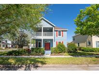 Charming two-story home with a balcony, red shutters, well-manicured lawn and lush landscaping at 6919 Cupseed Ln, Harmony, FL 34773