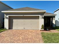 Charming single-Gathering home featuring a two-car garage and a brick-paved driveway at 813 Marcel Loop, Davenport, FL 33837