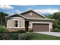 Charming single-Gathering home featuring a two-car garage, manicured landscaping, and stone accents at 1019 Wisteria Way, Dundee, FL 33838