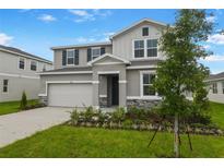 Charming two-story home with stone accents, landscaped yard, and attached two-car garage at 1027 Wisteria Way, Dundee, FL 33838