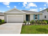 Charming single-story home with a two-car garage, landscaped yard, and lovely blue shutter at 1114 Olivine Ave, Dundee, FL 33838