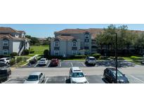 Beautiful two-story condo building featuring ample parking, well-maintained landscaping, and neutral stucco siding at 14049 Fairway Island Dr # 122, Orlando, FL 32837
