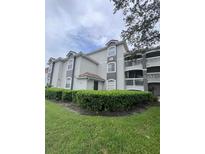Well maintained condo building with lush landscaping and a view from the front yard at 14049 Fairway Island Dr # 127, Orlando, FL 32837