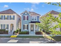 Charming two-story blue home with a well-manicured lawn and landscaping at 1589 Resolute St, Celebration, FL 34747