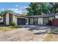 Charming single-story home featuring stone accents, a screened garage, and well-maintained landscaping at 2429 Oak Run Blvd, Kissimmee, FL 34744