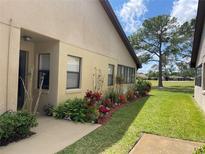Charming home featuring stucco exterior, colorful landscaping, and a well-manicured lawn at 2809 Wingfoot Ct, Winter Haven, FL 33884