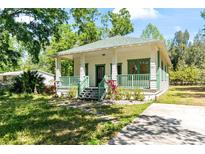 Charming home featuring a covered porch with green railings and a well-maintained front yard and driveway at 5641 Orange Ave, Intercession City, FL 33848