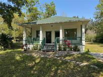 Charming home with a cozy front porch and well-maintained green accents and landscaping at 5641 Orange Ave, Intercession City, FL 33848