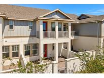Charming townhome featuring a covered porch, balcony, and well-maintained landscaping at 7063 Nemours Pkwy, Orlando, FL 32827