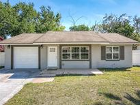 Charming single-Gathering home with a well-maintained lawn, attached garage, and inviting front entrance at 11125 Finchley Pl, Orlando, FL 32837